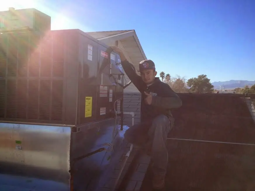 HVAC technician performing AC Tune-Up on a rooftop unit in Southwest Ranches